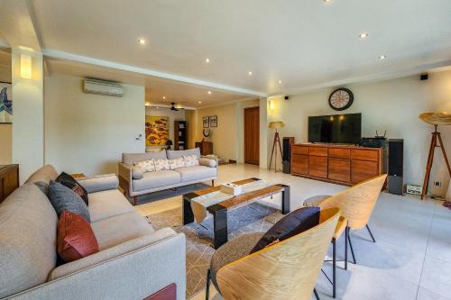 a living room with a couch and a tv at Da Vinci The Villa by Nagisa Bali in Tumbak Bayuh