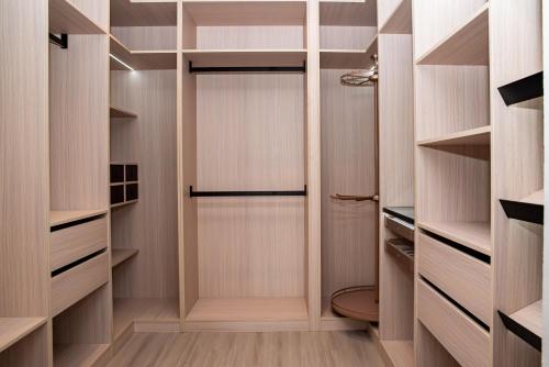 a walk in closet with wooden shelves and a door at Sunset Oasis Villa in Flic-en-Flac