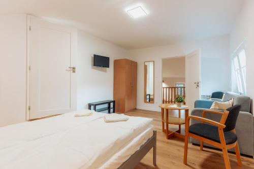 a bedroom with a bed and a chair and a couch at Zakątek u Hani in Polanica-Zdrój