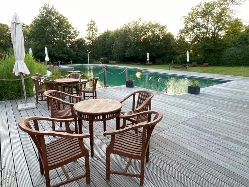 - une terrasse avec des tables et des chaises à côté de la piscine dans l'établissement Ferienhaus LebenPUR Bio-Ferienhaus aus Holz, à Parin