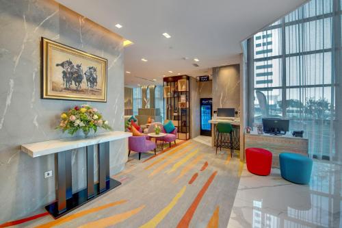 an office with a lobby with colorful furniture and windows at La Quinta by Wyndham Abu Dhabi Al Wahda in Abu Dhabi