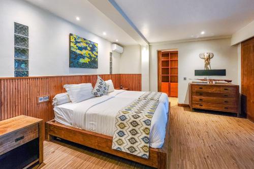 a bedroom with a bed and a dresser in it at Da Vinci The Villa by Nagisa Bali in Tumbak Bayuh