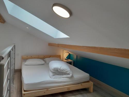 - un petit lit dans une chambre dotée d'un mur bleu dans l'établissement LAC à PIED ! Lumineux Studio-Mezzanine, TV, WIFI, 2parking, à proximité immédiate du Lac et du village de Saint Pardoux, à Saint-Pardoux