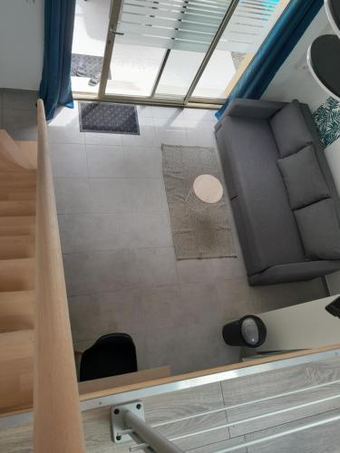 une petite chambre avec une chaise et un escalier dans l'établissement LAC à PIED ! Lumineux Studio-Mezzanine, TV, WIFI, 2parking, à proximité immédiate du Lac et du village de Saint Pardoux, à Saint-Pardoux