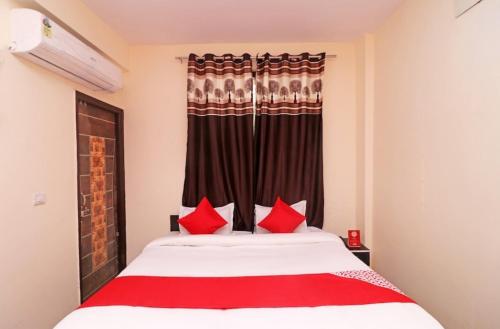 a bedroom with a large bed with red pillows at The Urban Villa in Noida