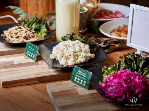 a table with plates of food on top at Daiwa Roynet Hotel Nagoya Eki Mae in Nagoya