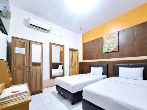 Ένα ή περισσότερα κρεβάτια σε δωμάτιο στο Nirvana Inn Gejayan Yogyakarta mitra RedDoorz