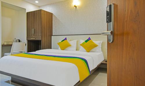 a bedroom with a bed with yellow and white pillows at Itsy Hotels Deluxe Inn in Chennai