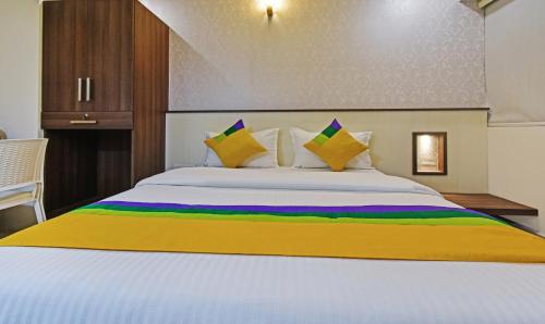 a bedroom with a large white bed with colorful pillows at Itsy Hotels Deluxe Inn in Chennai