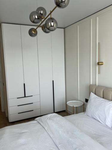 a bedroom with white cabinets and a white bed at Light 2-кімн Нова стильна квартира на Київській in Ternopilʼ