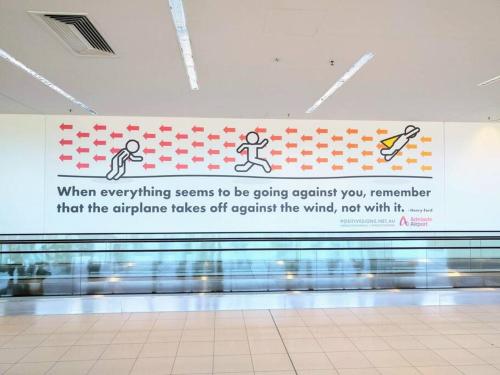 a sign in a airport with a banner on the wall at No Stairs, Big House, Garage Richmond Residence 2 in West Richmond