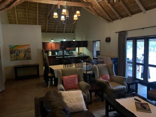 a living room with chairs and a table and a kitchen at Leriba Lodge Unit425 in Phalaborwa
