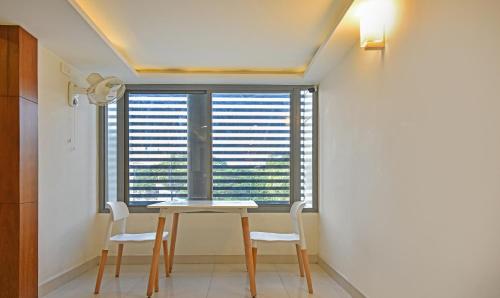 a table and chairs in a room with a window at Itsy Hotels Deluxe Inn in Chennai