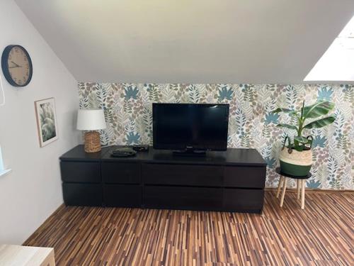 a living room with a flat screen tv on a dresser at Willa Sarbinowo in Sarbinowo