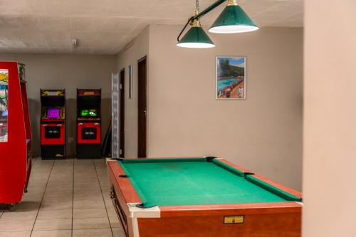 a room with a pool table and arcade machines at ATKV Klein-Kariba in Bela-Bela
