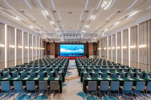 an empty conference room with a large screen at YTL ChangChengYunYue Hotel in Wenzhou