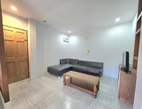 Una sala de estar con un sofá y una mesa de café. en Family room, en Ban Phayun
