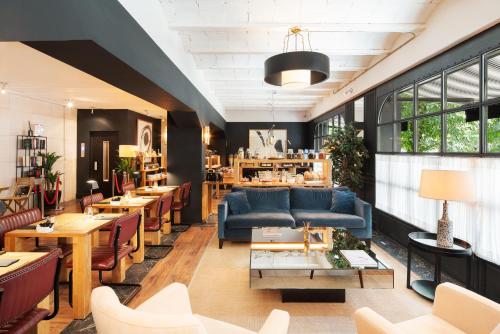 a restaurant with a blue couch and tables and chairs at La França Travellers Adults Only in Barcelona