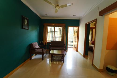 a living room with green walls and chairs at Ramana Towers in Tiruvannāmalai