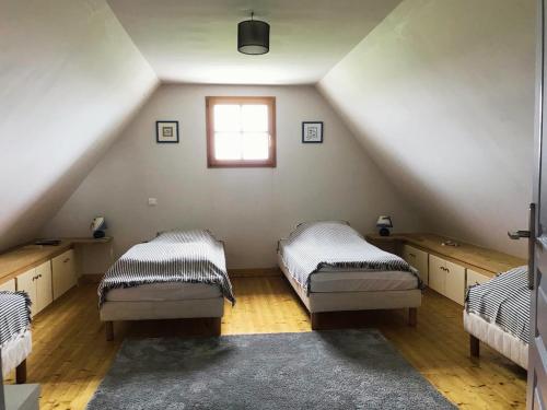 a attic room with two beds and a window at Longère - 10 personnes - Vue mer in Tréguennec