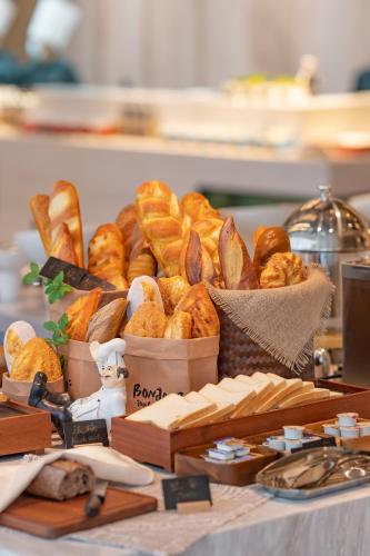 a table topped with baskets of bread and pastries at YTL ChangChengYunYue Hotel in Wenzhou