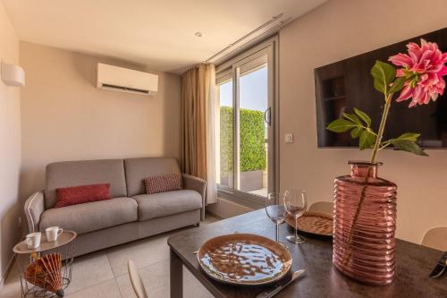 a living room with a couch and a table with a vase with a flower at At home in Clermont, Place de Jaude in Clermont-Ferrand