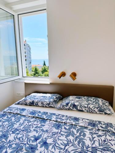 リエカにあるLuxury Apartment AMÉS Rijekaのベッドと窓のある寝室