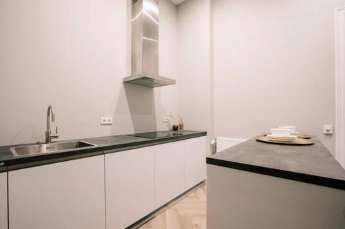 a white kitchen with a sink and a counter top at City Center Poppodium 013 Stadsvilla Tilburg in Tilburg