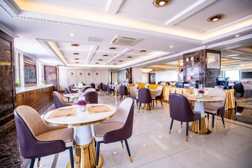 a restaurant with tables and chairs and a bar at ST Hotel Wattay Airport in Vientiane