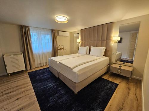 a bedroom with a large bed and a large window at Hotel Queen in Râmnicu Vâlcea