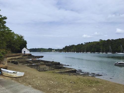 a body of water with a small white house and boats at Longère - 10 personnes - Vue mer in Tréguennec