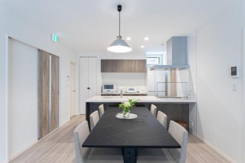 a kitchen and dining room with a black table and chairs at Mova Villa Haramizu in Kikuchi