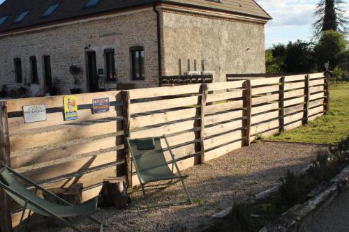 a couple of chairs sitting next to a fence at Les Blés Dorés et Les Graines de Lin, 2 gîtes à la Ferme avec moutons et piscine, à côté de Beaune in Corgengoux