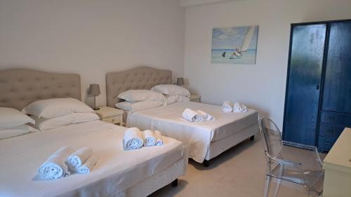 a bedroom with two beds with towels on them at Villa Agapanto in Paestum