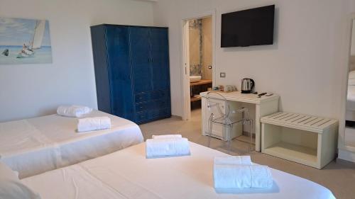 a room with two beds and a desk and a television at Villa Agapanto in Paestum