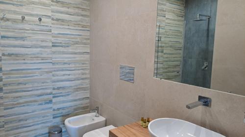 a bathroom with a sink and a toilet and a mirror at Villa Agapanto in Paestum