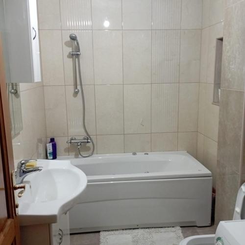 a bathroom with a bath tub and a sink at Petra in Livno