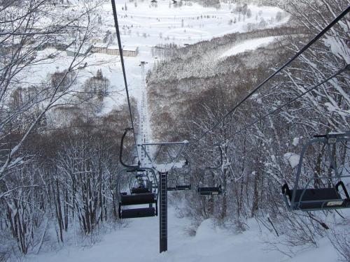 a ski lift with people on it in the snow at バートンホテル Barton Hotel in Shinano