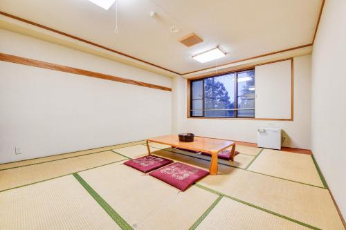 a room with a table and a window at バートンホテル Barton Hotel in Shinano