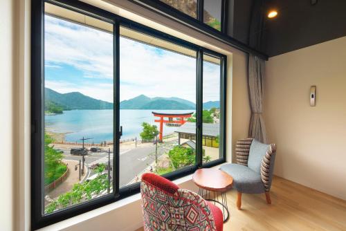 a room with a large window with a view of the water at Hotel Hanaan in Nikko