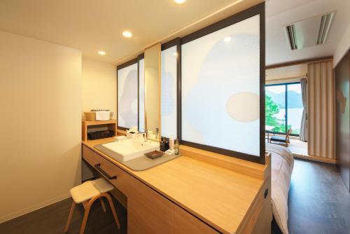 a bathroom with a sink and a large window at Hotel Hanaan in Nikko