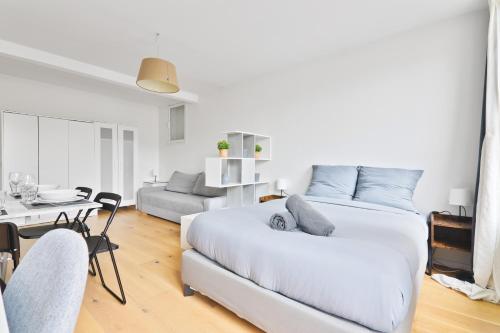 - une chambre blanche avec un lit et un salon dans l'établissement Studio - Appartement Quartier Champs-Élysées 5 Free Netflix, à Paris