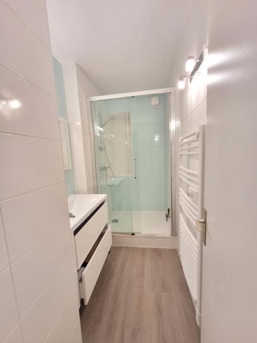 une salle de bain avec une douche à l'italienne et une porte vitrée dans l'établissement La Rochejacquelein, à Saint-Jean-de-Monts