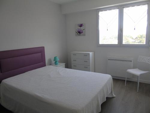 une chambre blanche avec un lit et une chaise dans l'établissement La Rochejacquelein, à Saint-Jean-de-Monts