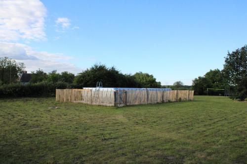 a wooden fence in the middle of a field at Les Blés Dorés et Les Graines de Lin, 2 gîtes à la Ferme avec moutons et piscine, à côté de Beaune in Corgengoux