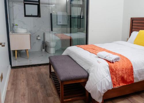a bedroom with a bed and a glass shower at Greyscape Apple Tree Apartment in Nairobi