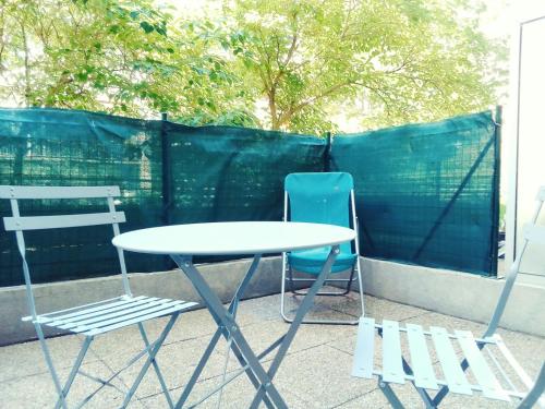 - une terrasse avec 2 chaises et une table et des chaises blanches dans l'établissement Joli studio avec terrasse, à Marseille