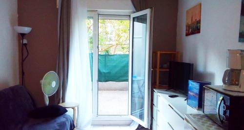 d'un salon avec une porte coulissante en verre s'ouvrant sur une terrasse. dans l'établissement Joli studio avec terrasse, à Marseille