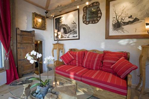 a living room with a red couch and a glass table at Hôtel Les Chalets de Philippe avec Jacuzzis Privatifs in Chamonix-Mont-Blanc