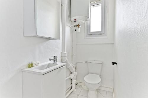 une salle de bain blanche avec des toilettes et un lavabo dans l'établissement Serenity spot at Gagny- Near Paris- III, à Gagny